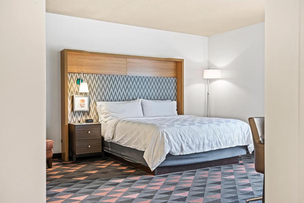 a bedroom with a large bed and a nightstand at Holiday Inn - St. Petersburg West by IHG in St Petersburg