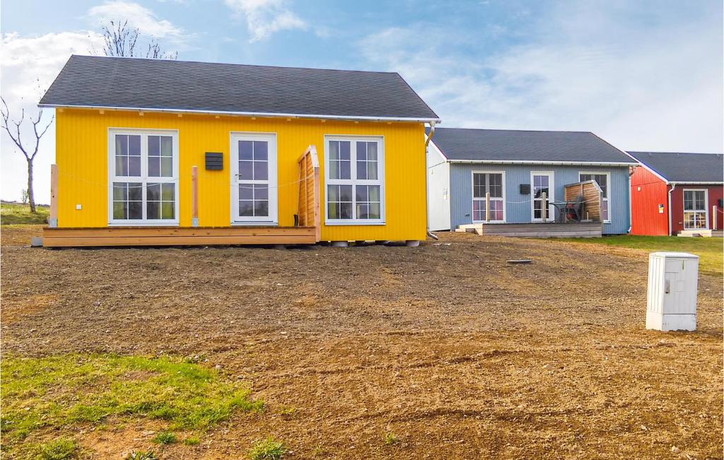 a yellow house in a field with a yard at Nice Home In Olbernhau With Kitchen in Pfaffroda