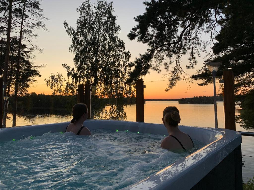 a woman is sitting in a pool of water at Hotelli Salpa in Luumäki