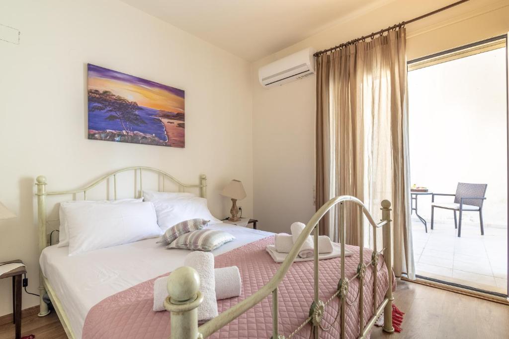 a bedroom with a bed and a balcony at Apartment Mariandi in Pitsidia