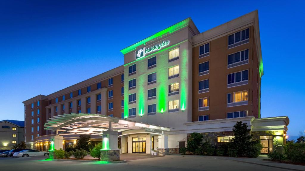 un hotel con un letrero verde en la parte delantera en Holiday Inn Oklahoma City Airport, an IHG Hotel en Oklahoma City