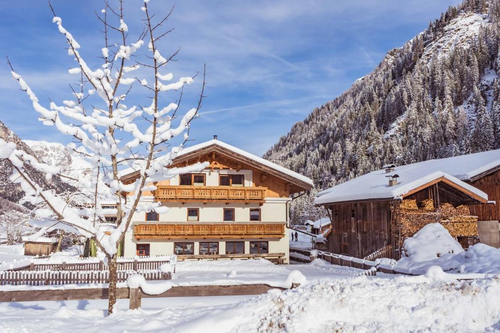 uma casa na neve em frente a uma montanha em Gasthof Feuerstein em Gschnitz