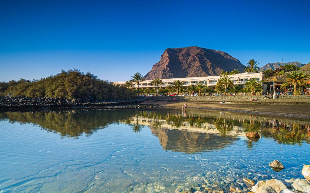 a view of a beach with a mountain in the background at Apartamentos Charco del Conde in Valle Gran Rey