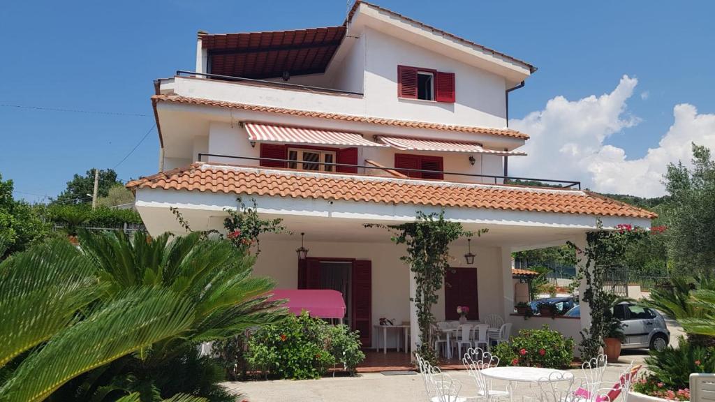 a white house with red windows and a patio at Casa Vacanze Angelo in Palinuro