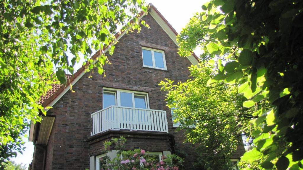 a brick building with a balcony and trees at Privatzimmer Hamburg Alsterdorf in Hamburg