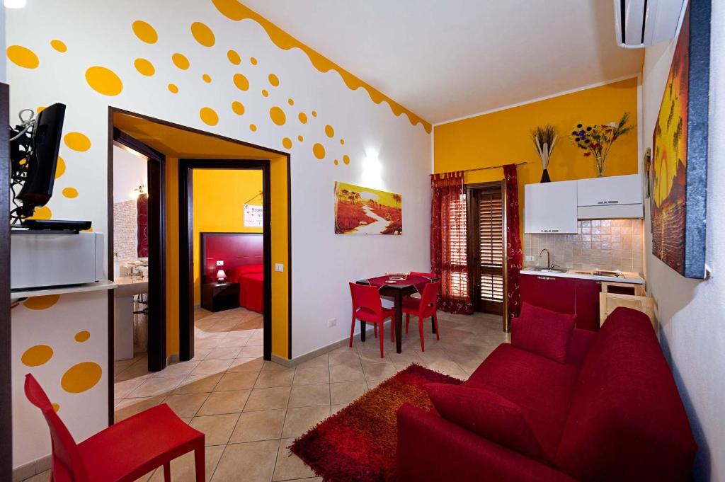 a living room with a red couch and a kitchen at Residence Mareluna in Castellammare del Golfo