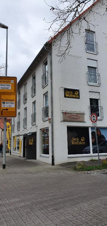 a white building with a sign on the side of it at Outletcity Ferienwohnung Wohnung 1 in Metzingen