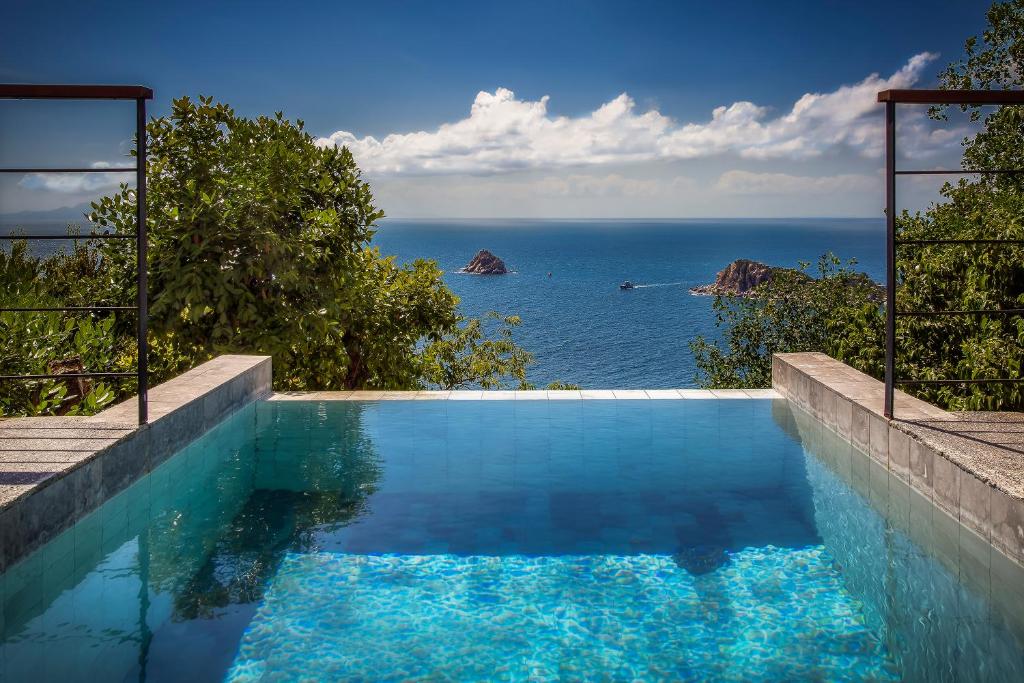a swimming pool with a view of the ocean at Philip's Villa in Koh Tao