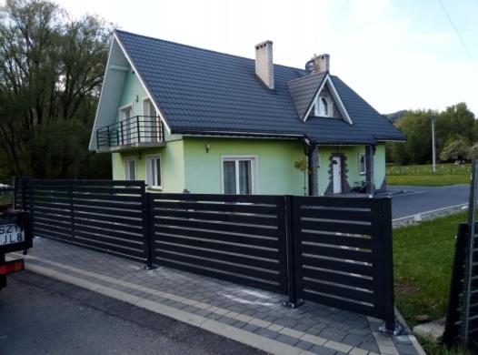 uma casa com uma cerca preta em frente em Willa na Wczasowej em Wegierska Górka