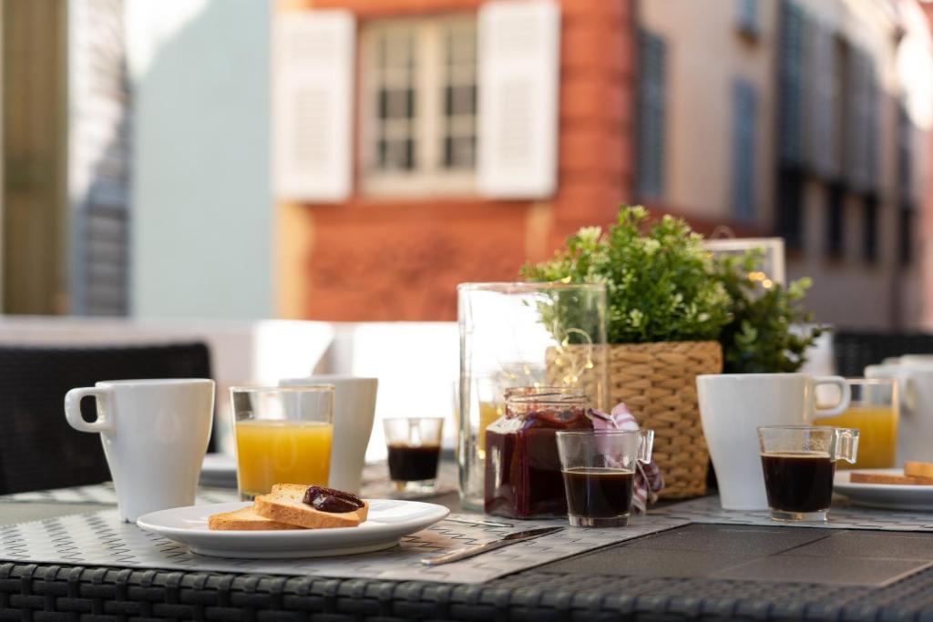 a table with a breakfast of orange juice and toast at Family Apartments Angeli in Genoa