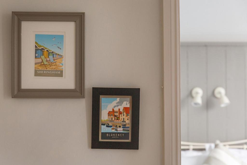 two framed pictures on a wall next to a mirror at The Sands Sheringham in Sheringham