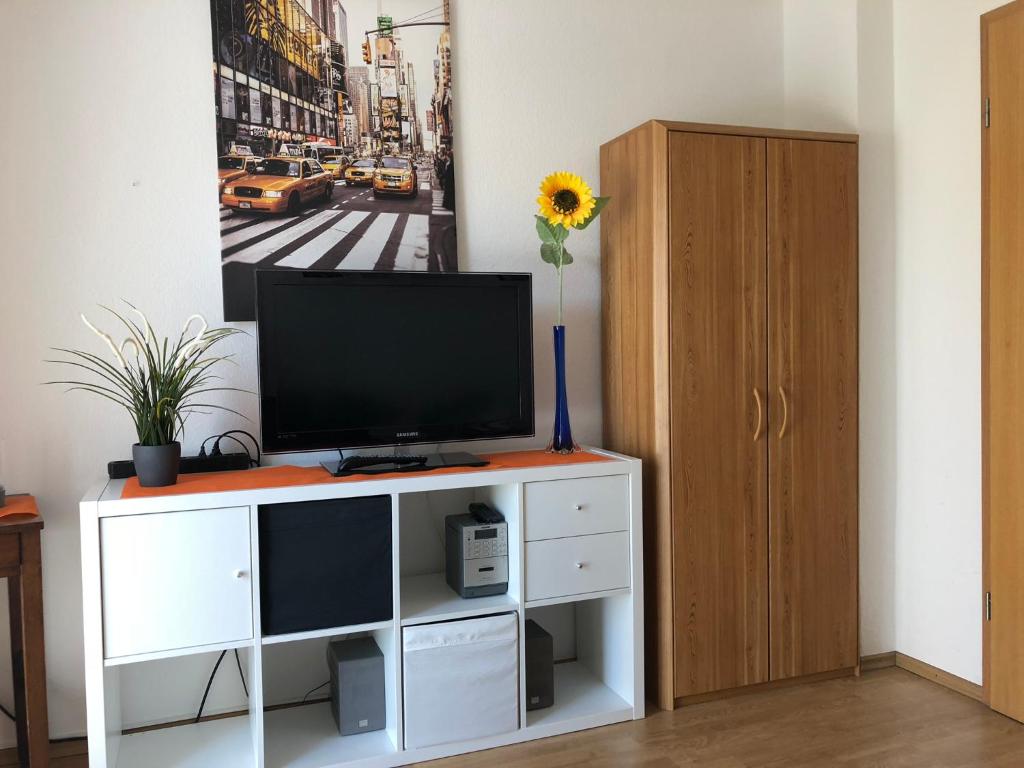 una sala de estar con TV en un centro de entretenimiento blanco en 2 Zimmer Wohnung mit Balkon - Nähe Messe, en Haar