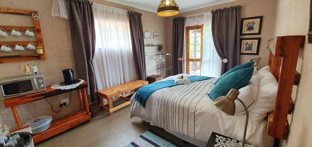 1 dormitorio con 1 cama y TV en Thaba Lapeng Mountain Escape en Clarens