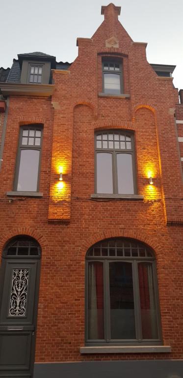 B&B Heart Of Bruges في بروج: مبنى من الطوب الأحمر مع نوافذ وأضواء عليه