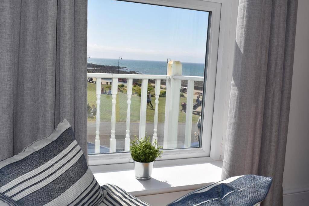 Habitación con ventana y vistas al océano. en Drift Away Apartment, en Westward Ho