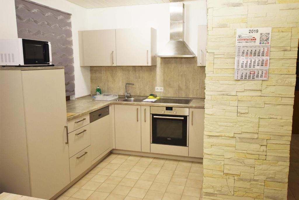 a kitchen with white cabinets and a sink and a refrigerator at Apartment Möhringen in Stuttgart