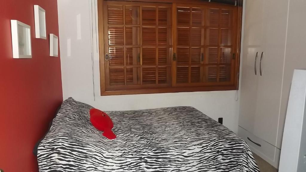 Un dormitorio con una cama con una almohada roja. en Alugo quarto com internet, en Porto Alegre