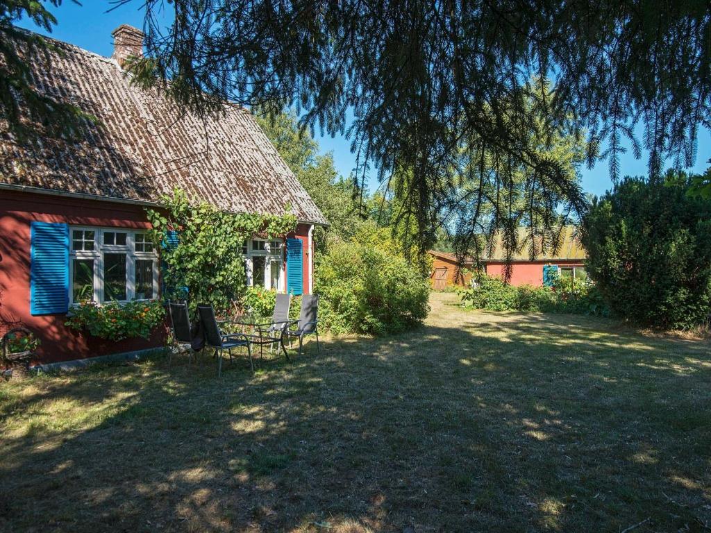 une maison rouge avec un banc devant elle dans l'établissement 6 person holiday home in Br dstrup, à Hårup