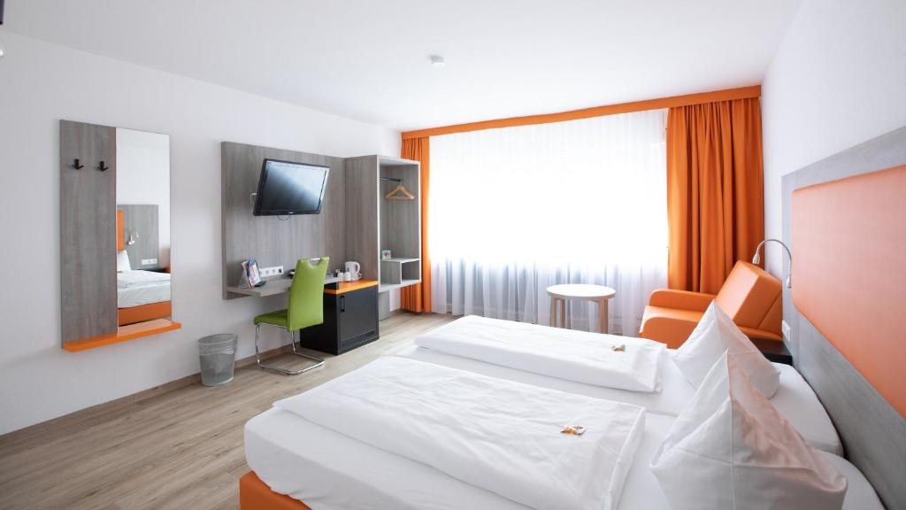 een hotelkamer met een bed en een televisie bij Hotel Elite in Karlsruhe