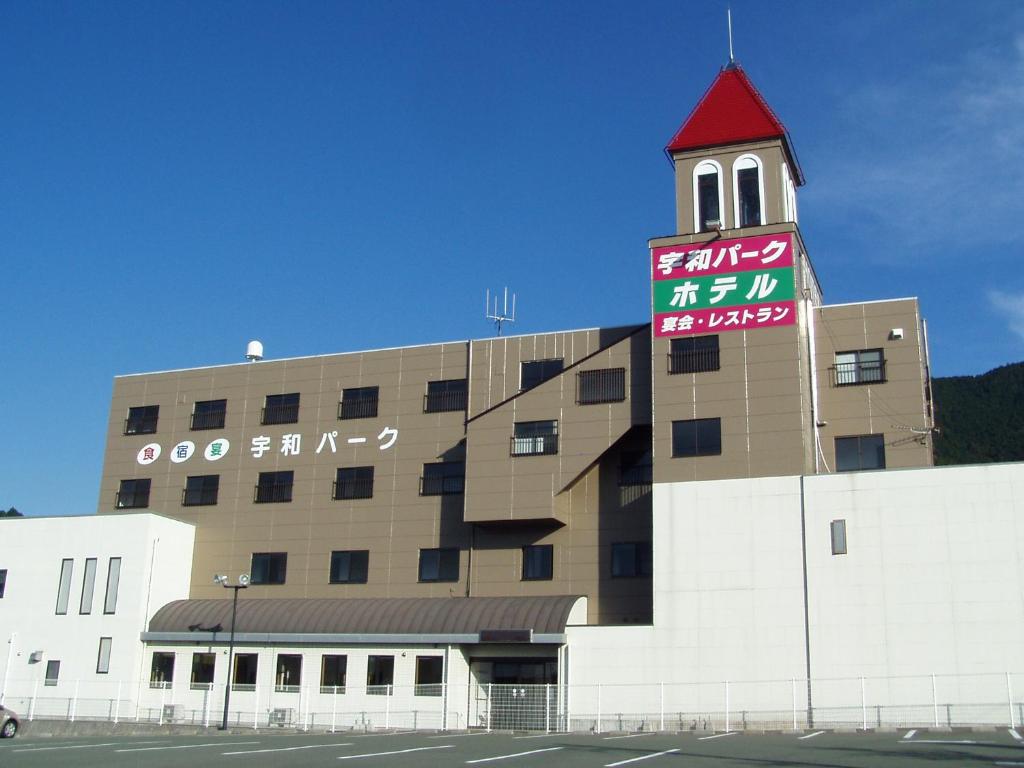 un edificio con una torre de reloj encima en 宇和パークホテル, en Seiyo