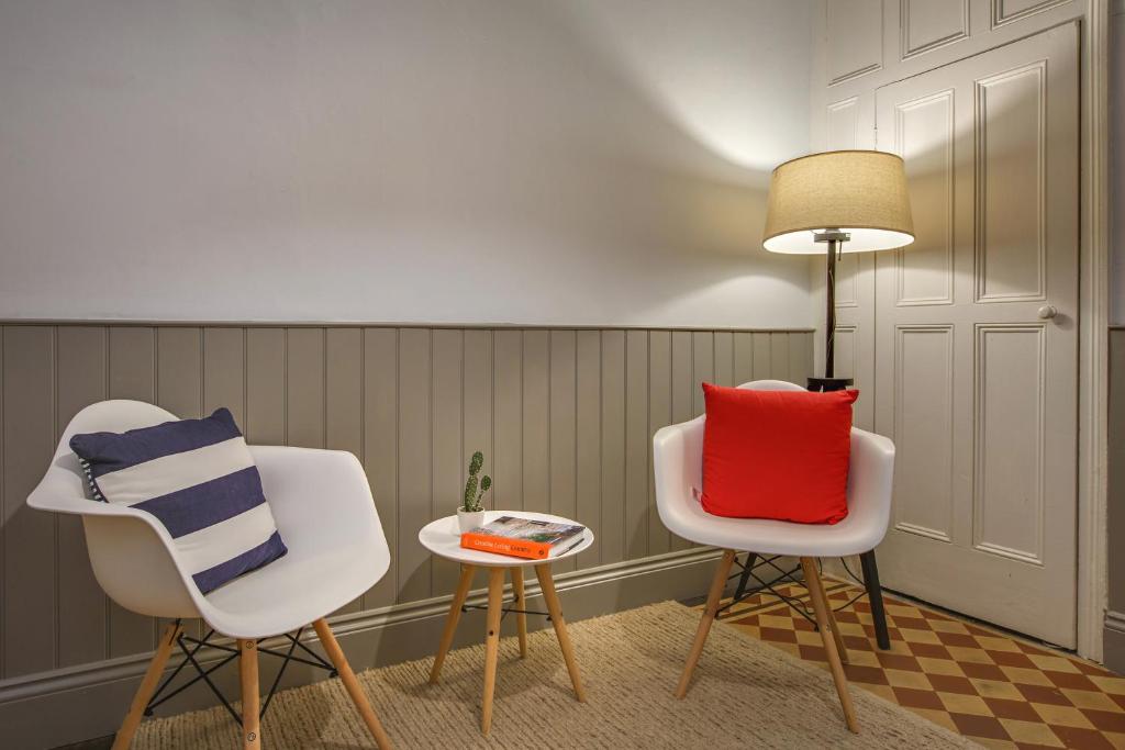two chairs and a table with a lamp in a room at The Sands Sheringham in Sheringham