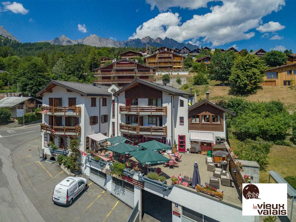 eine Luftansicht eines Hotels mit Parkplatz in der Unterkunft Le Vieux Valais in Ovronnaz