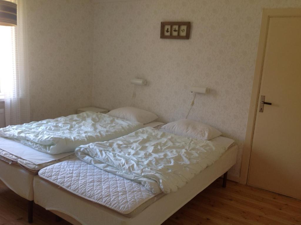 a bed with white sheets and pillows on it at Parhus i Rönneshytta in Rönneshytta