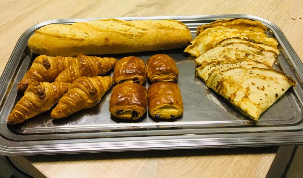 a tray of pastries and bread on a table at Le Petit Brétigny in Beaumont