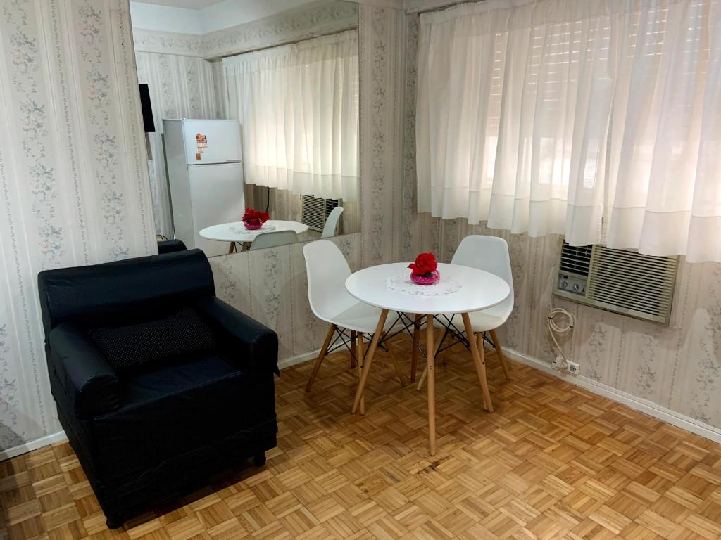 ein Wohnzimmer mit einem Tisch und einem Stuhl in der Unterkunft DEPARTAMENTO COCA in Buenos Aires