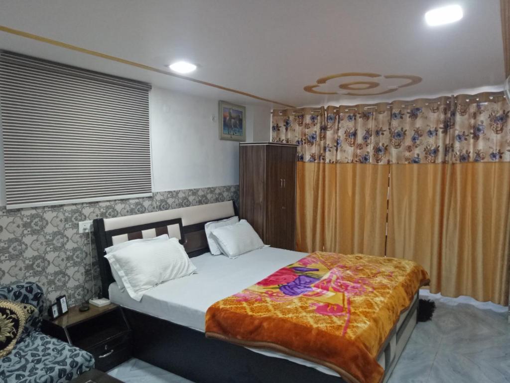 um quarto com uma cama e uma cadeira em Traveller Guest House em Varanasi