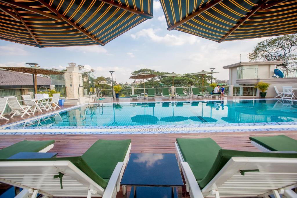 a large swimming pool with chairs and tables at Prestige Residences at Golden Valley by Grand United Hospitality in Yangon