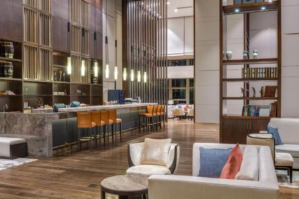 a lobby of a hotel with chairs and a bar at Crowne Plaza Chongqing New North Zone, an IHG Hotel in Chongqing