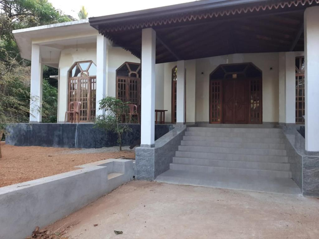 een huis met een veranda en een trap aan de voorkant bij The Golden Residence in Kegalle