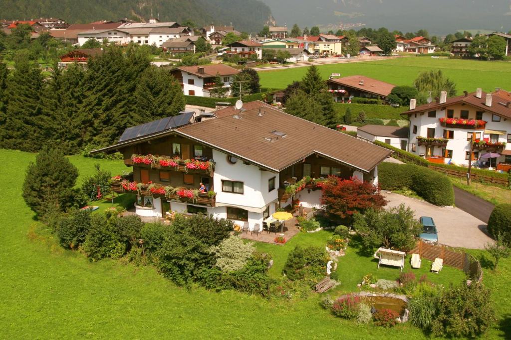 a large house with flowers in the front yard at Gästehaus Wildauer in Schlitters