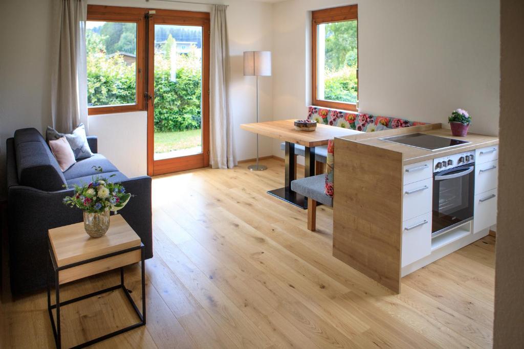 uma cozinha e sala de estar com um sofá e uma mesa em Laura´s Smart Apartment em Innsbruck