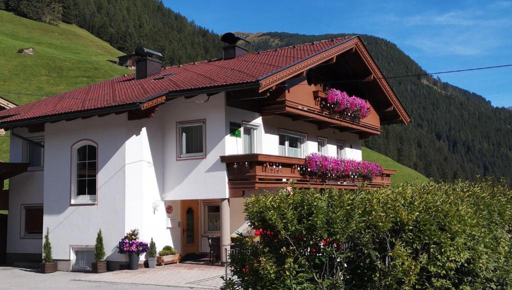 a house with flowers on the balconies of it at Ferienwohnung Alpenheim in Tux