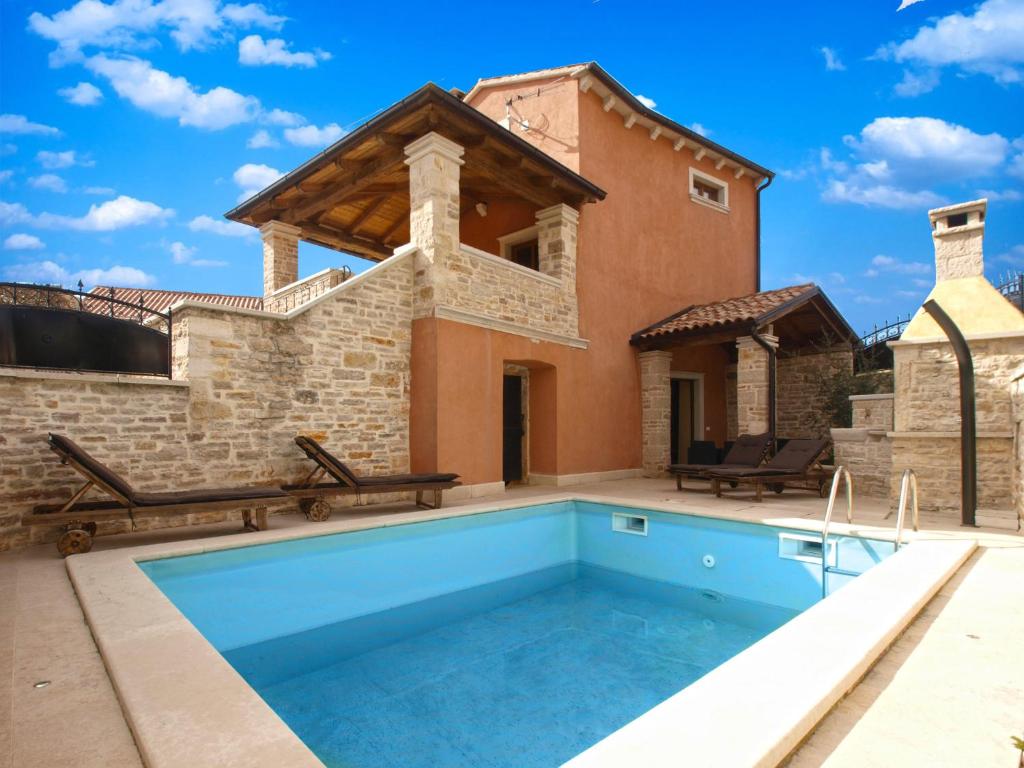 a villa with a swimming pool and a house at House Jasici 2014 in Žminj