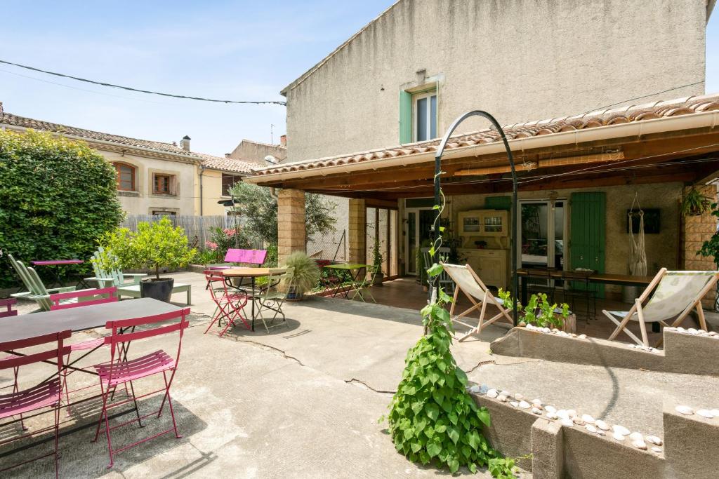 eine Terrasse mit einem Tisch und Stühlen sowie ein Gebäude in der Unterkunft La Clé d'Or in Servian