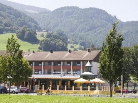a large building with umbrellas in front of a mountain at Parkhotel Wangs in Wangs