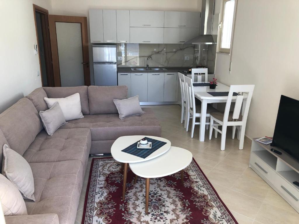 sala de estar con sofá, mesa y cocina en Rooftop Apartments Lungomare en Vlorë