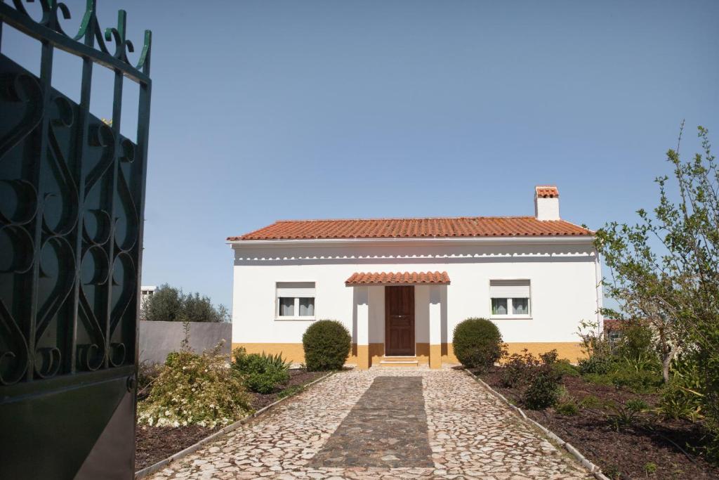 a white house with a gate and a driveway at monte da boa fé in Estremoz