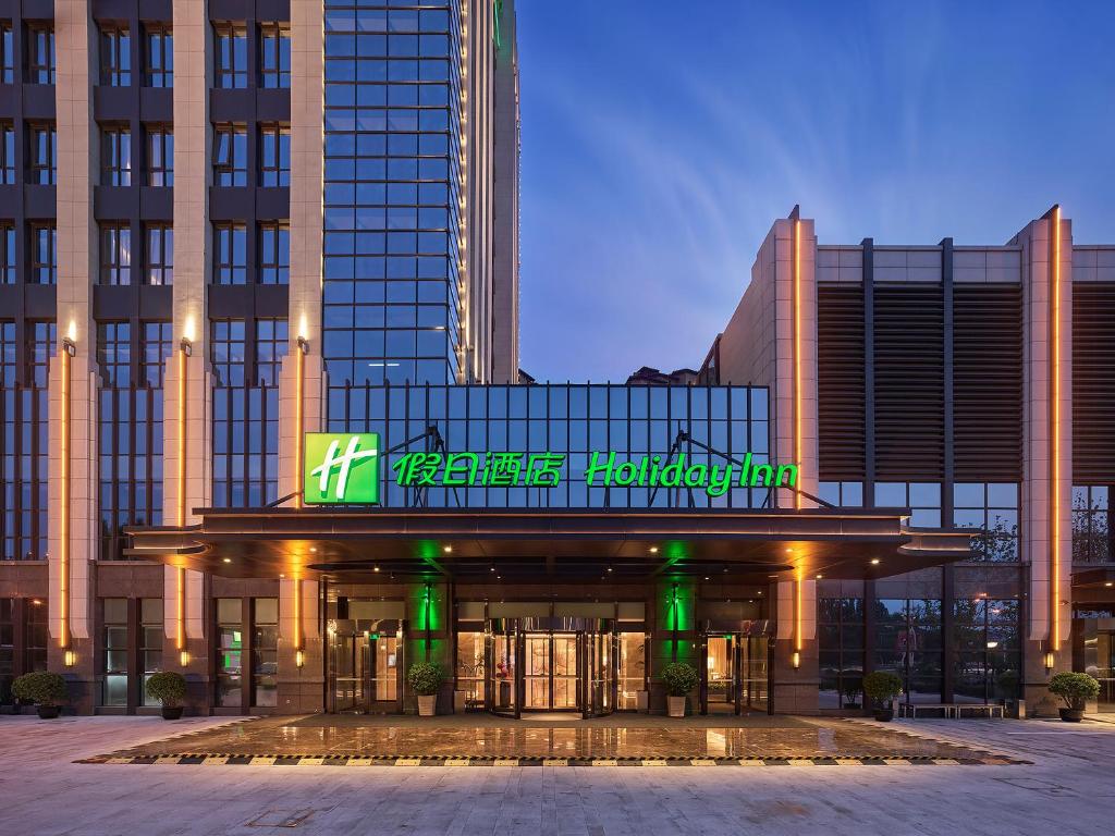 a building with a sign on the front of it at Holiday Inn Tianjin Wuqing, an IHG Hotel in Wuqing