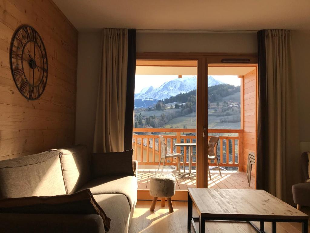 a living room with a couch and a table at Luxury 2 Bedroom Apartment with view of Mont Blanc in Combloux