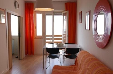 ein Wohnzimmer mit einem Tisch und einem Sofa in der Unterkunft Orange Home in Marina di Castagneto Carducci