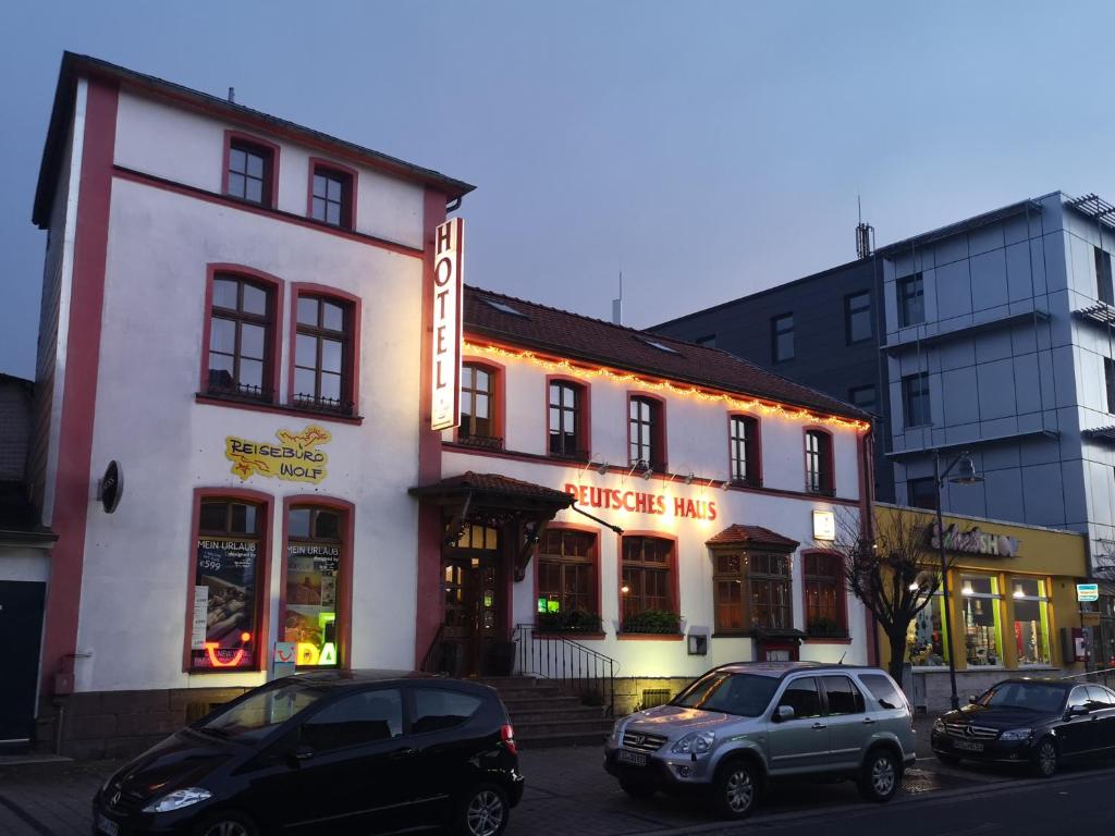 two cars parked in front of a white building at HotelDeutschesHaus Leinefelde in Leinefelde