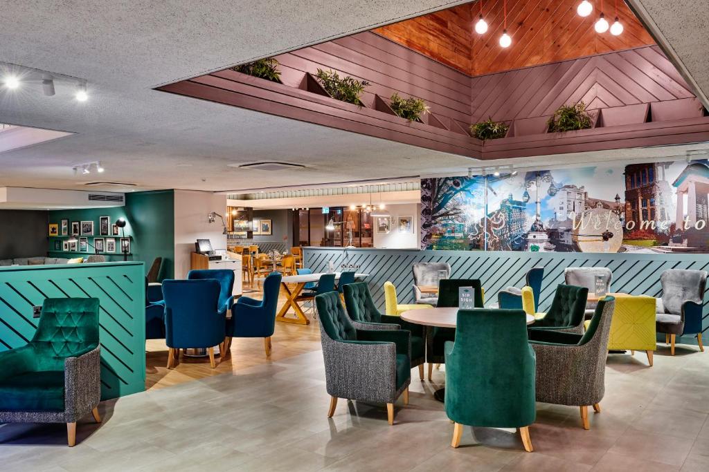 een restaurant met kleurrijke stoelen en tafels in een kamer bij Holiday Inn Taunton M5, Jct25, an IHG Hotel in Taunton