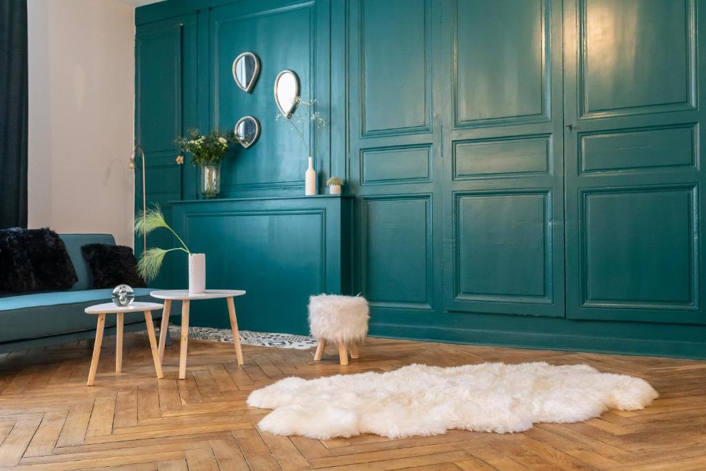a living room with a blue wall and a white rug at LE CARPE DIEM in Tours