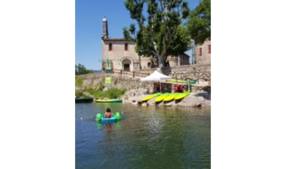 een persoon op een paddleboard in het water bij gite de l'église in Laroque