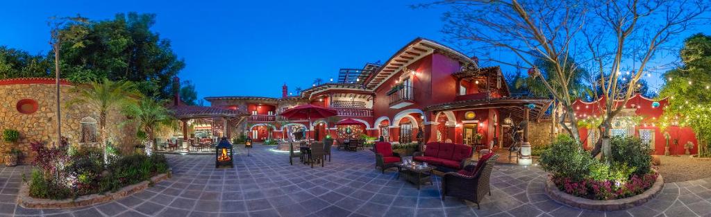 un bâtiment avec des chaises et des tables dans une cour dans l'établissement Hotel Boutique Casa Colorada, à Pátzcuaro