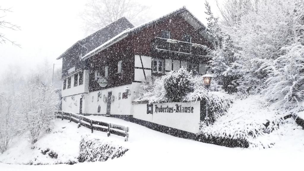 un edificio cubierto de nieve con un cartel delante en Jeje und Anna's Eifel Haus, en Monschau